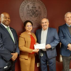 Four people stood together for a photo wearing formal attire 