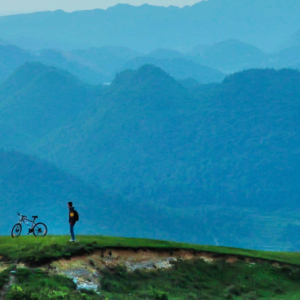 Biker ponders mountain landscape