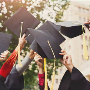 Hands holding graduation caps in the air.