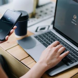 Person working on laptop and phone