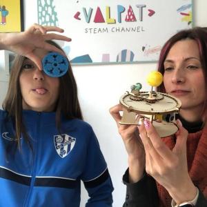 Valeria Coralles and another playing with circular devices. Valeria sticking her tongue out. "ValPat Steam Channel" on a sign behind them.