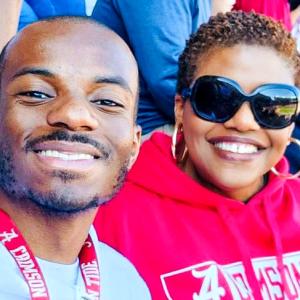 Two people sat next to each other smiling 