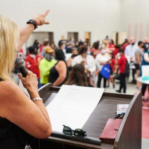 Principal Fairless directs families to stations in the school’s multipurpose room. Credit: Saeed Rahbaran
