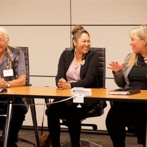 Veronica and two others seated at a long desk in an office setting.