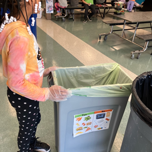 Small child stood next to a food waste bucket