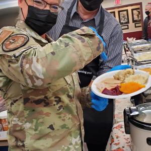 two volunteers holding plate of food 