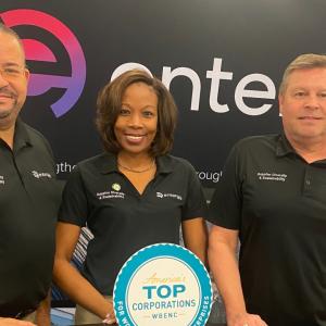 From left, Rivers Frederick, Kya Moller and Dan Boren stood in front of the entergy logo at the WBENC conference