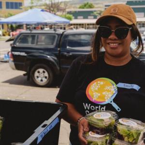 Person holding multiple salad boxes