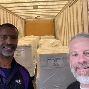 two people smiling with packages in background