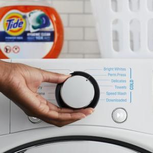 Person turning the dial on a washing machine 
