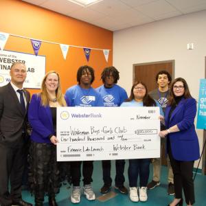 Group celebrating with oversized check