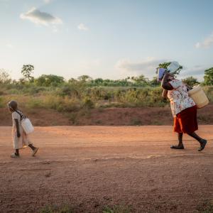 Celestine and her grandmother carrying water