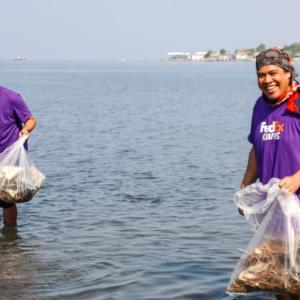 Group of Volunteers holding bags in water