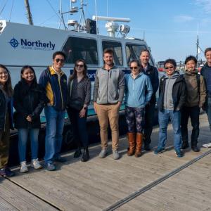 Ian Crossland and group on dock next to a boat