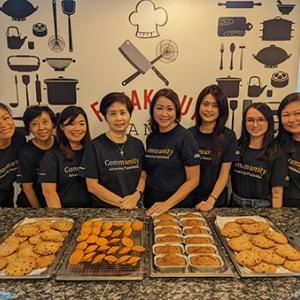 A group of Boston Scientific employees in Singapore standing behind trays of cookies
