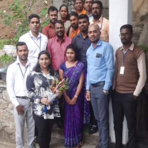 A group of people, one with a bouquet of flowers.