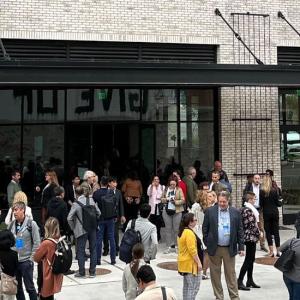 A group of scattered people outside a building