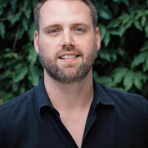 Headshot of Matthew Wemple against a background of leaves