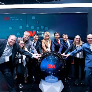 Wendy Bauer and team touching the award that they received.