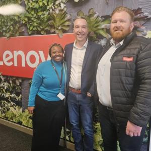 Werner Schoeman and team members in front of a Lenovo sign.