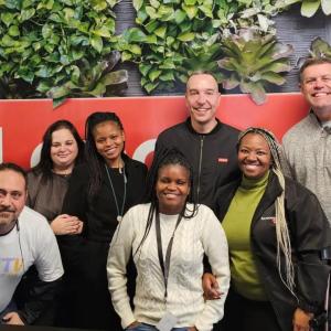 Werner Schoeman and team members in front of a Lenovo sign.