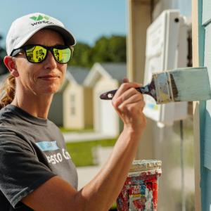 Wesco team member painting the house.