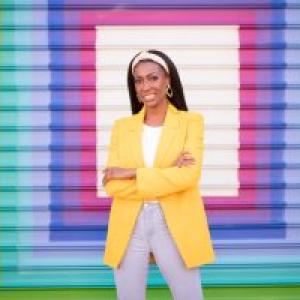 Wesley Hicks in front of a rainbow concentric square mural