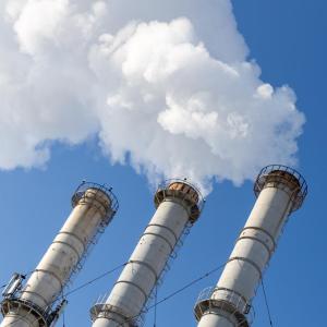Smoking pipes making clouds against blue sky background