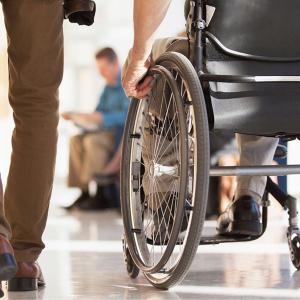 A person next to someone who is using a wheelchair 