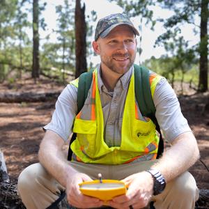 Will Ricks sat on a log in a forrest