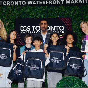 Students holding drawstring Tata Consultancy Services bags
