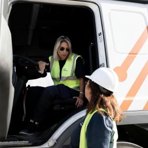 Two women wearing safety vests and hard hats speak beside a truck at a DP World terminal in Argentina.