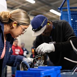 Two people work on electronics