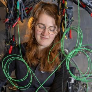 Woman working among various cables