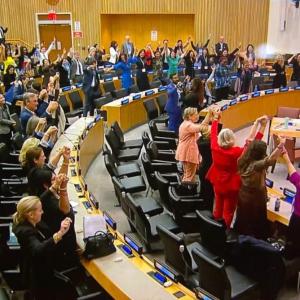 People in an auditorium raising their hands