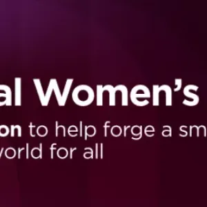 International Women's Day banner and Lenovo logo. A person stepping up large red blocks outdoors.