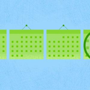 Magnifying glass held over a calendar.