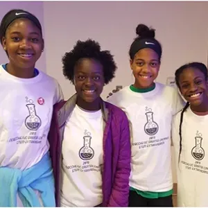 4 people stood next to each other smiling