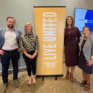 4 people, 2 either side of a banner stand