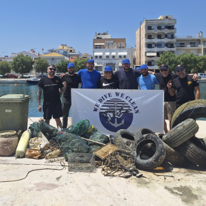 Group photo of volunteers next to the large pile of garbage they removed from the water