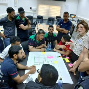 Group standing and looking over paper laid out on table