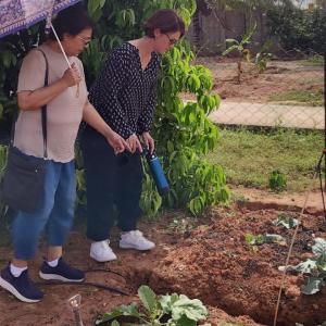 Two people stood next to each other looking at some crops 