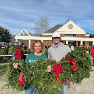 people holding up wreaths