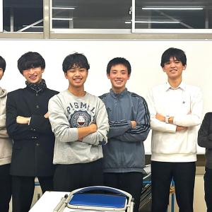 Student group standing in front of white board.
