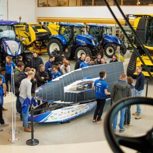 People stood around a solar car at Zedelgem showroom