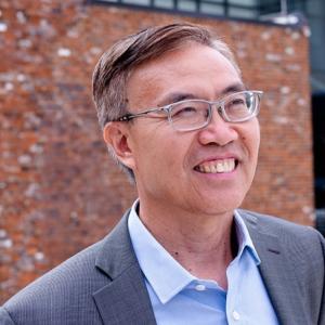 Ben Zhang outside, a brick building in the background