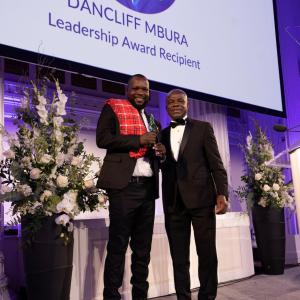 Dancliff Mbura accepts the Leadership Award from Dr. Charles E. Owubah, CEO of Action Against Hunger