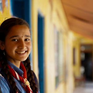 A smiling child standing in a hallway