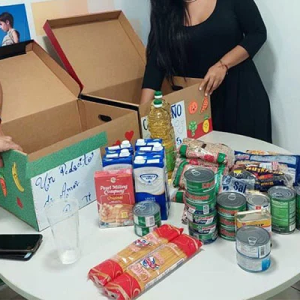 In a home kitchen, two people pack boxes with food