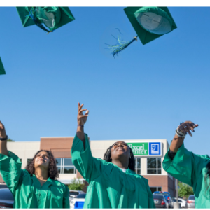 People in graduation gowns throwing caps.